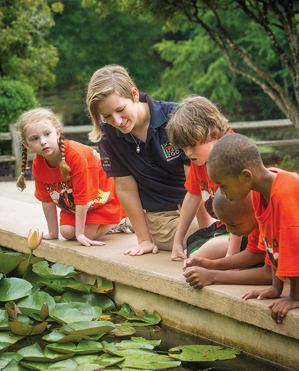 Photo of student Alexis Helton with Birmingham Zoo campers at pond