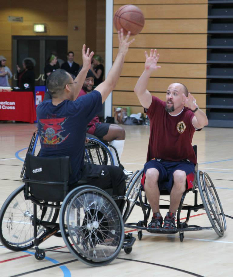 Photo of Christopher Ebner participating in a wheelchair basketball game for soldiers.