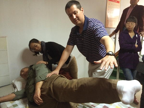 Photo of Scott Bickel working with a Chinese patient.