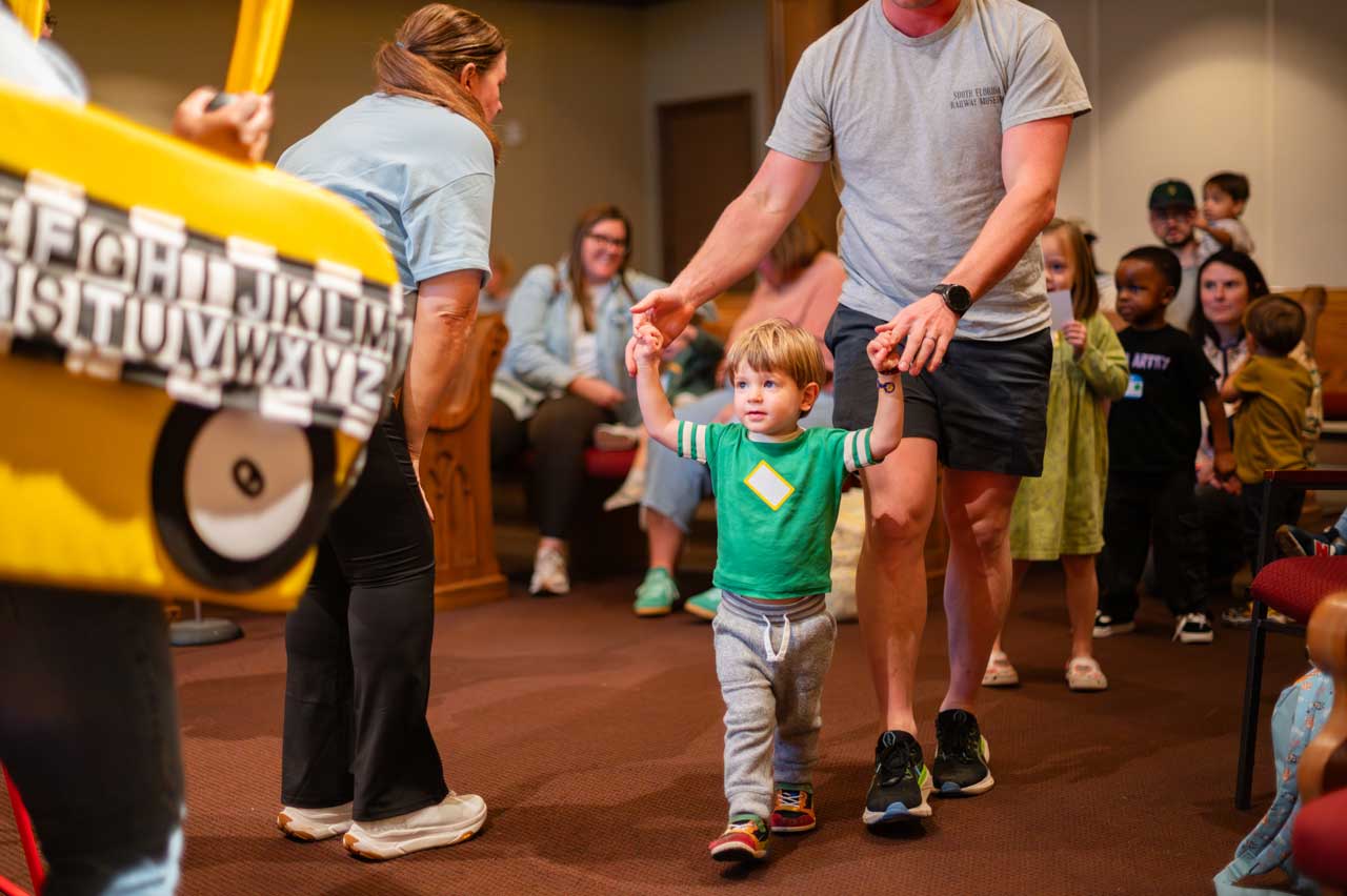 Boy and father  are participating in a community vocabulary teaching event at a local church.