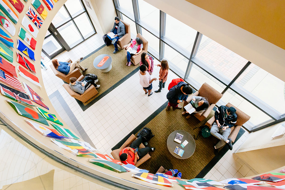 View of the lobby of the Ryals building from the second floor balcony, flags of many nations on display. 